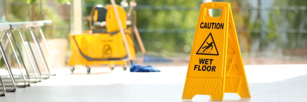 wet floor sign, mop in background, commercial building