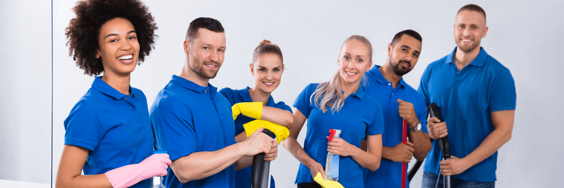 Portrait Of Happy Male And Female Cleaning Crew With Cleaning Equipment