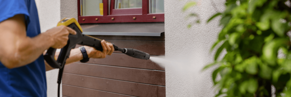 close up of a man holding a power washer or pressure washer, commercial or residential high pressure cleaning