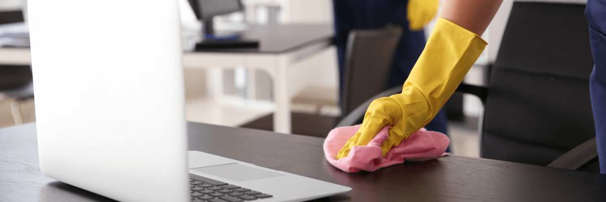 commercial cleaner wiping office desks